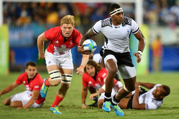 Fiji's Semi Kunatani runs with the ball in the men ?? s rugby sevens gold medal match between Fiji and Britain during the Rio 2016 Olympic Games at Deodoro Stadium in Rio de Janeiro on August 11, 2016. / AFP PHOTO / Pascal GUYOT