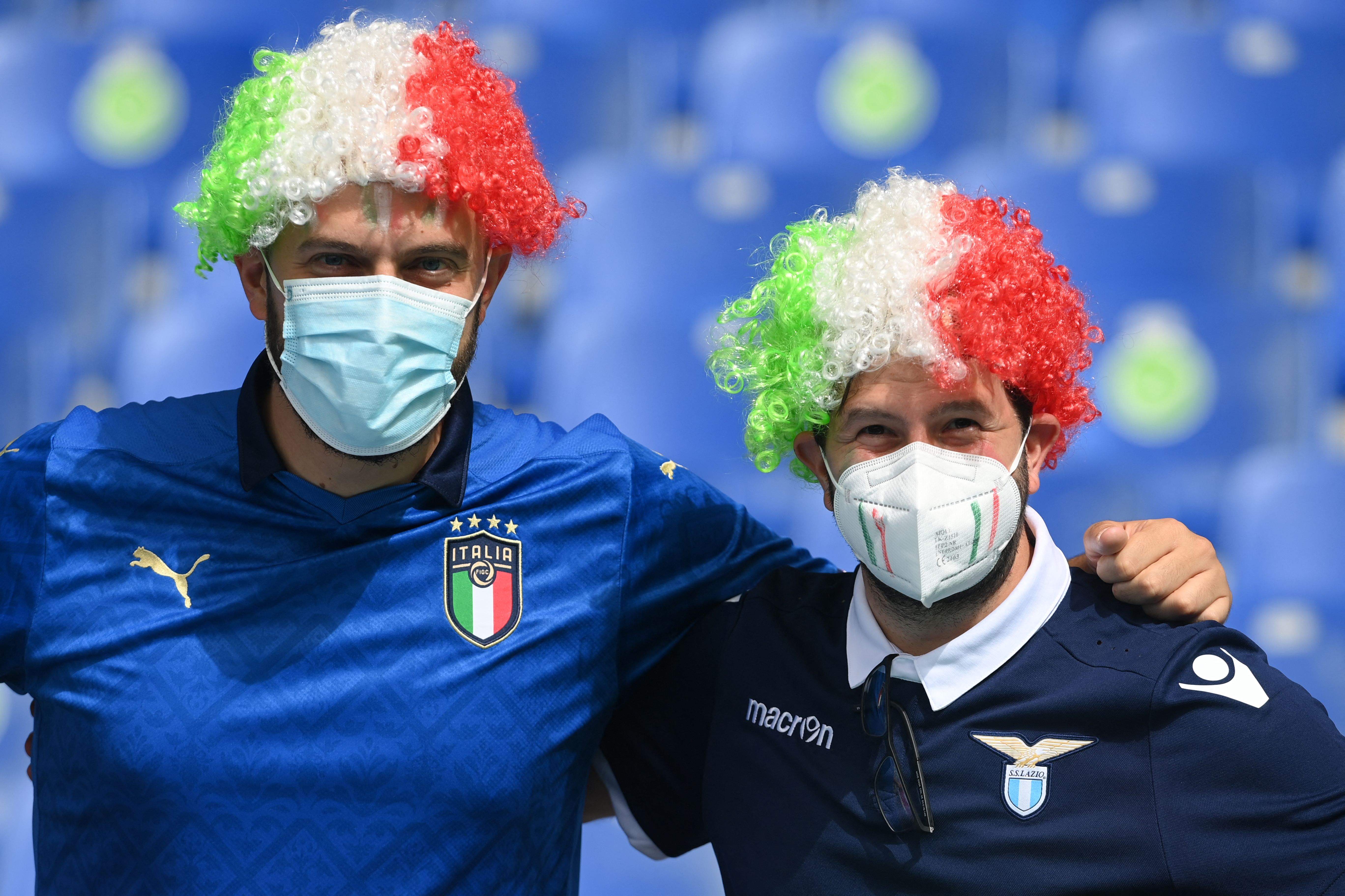 Italy fans pose with masks as a precaution against the transmission of the new coronavirus before the UEFA EURO 2020 Group A soccer match between Italy and Wales at the Olympic Stadium in Rome on June 20, 2021