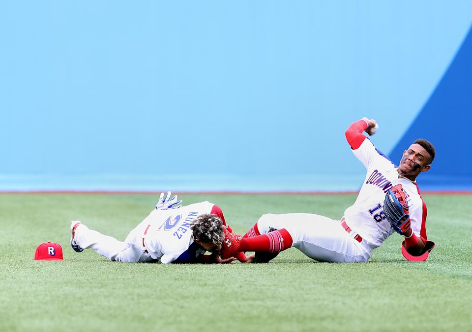 YOKOHAMA, JAPAN - JULY 30: Julio Yamel Rodriguez Reyes # 18 of Team Dominican Republic throws the ball to the infield after collididing with Gustavo Nunez Castillo # 2 in the third inning during the baseball opening round Group A game on day seven of the Tokyo 2020 Olympic Games at Yokohama Baseball Stadium on July 30, 2021 in Yokohama, Kanagawa, Japan. (Photo by Koji Watanabe / Getty Images)