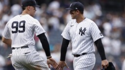 Two Yankees players between brands of Venezuelans on Opening Day
