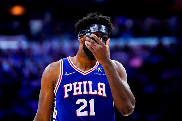 With his mask on, Embiid covers his face from the pain of being left out with his Sixers.